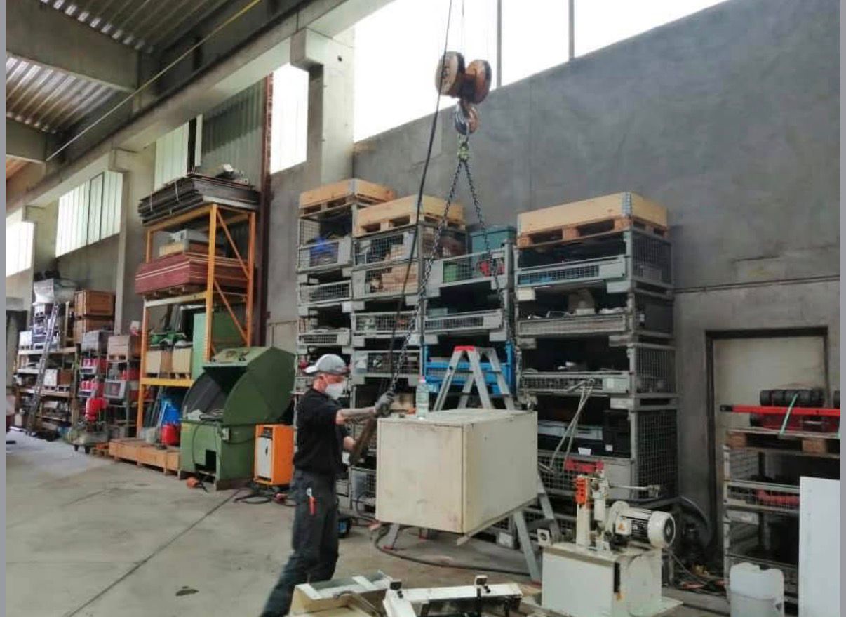 Hallenkran hebt Maschine